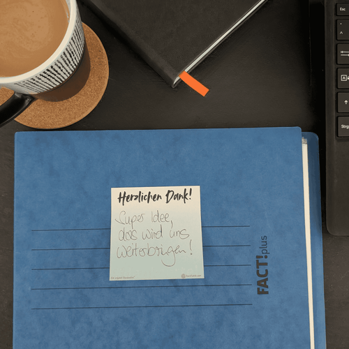 Kleiner beschriebener Dankzettel auf einer Akte aus hochwertigem Papier für Teams, Kollegen und Büros um Wertschätzung auszudrücken.