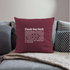 Design-Kissen „Dankfabrik“ in rot auf dem Sofa, hochwertiges Dekokissen mit Botschaft von Dankfabrik.